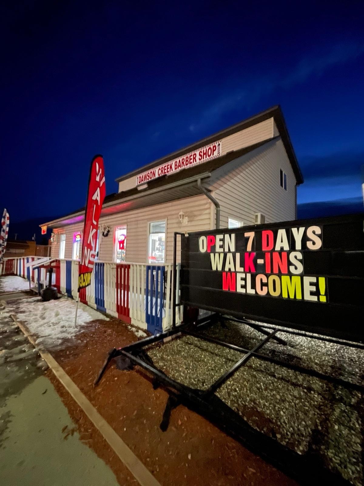 Dawson Creek Barbershop — Open 7 Days, Walk-Ins Welcome sign at dusk